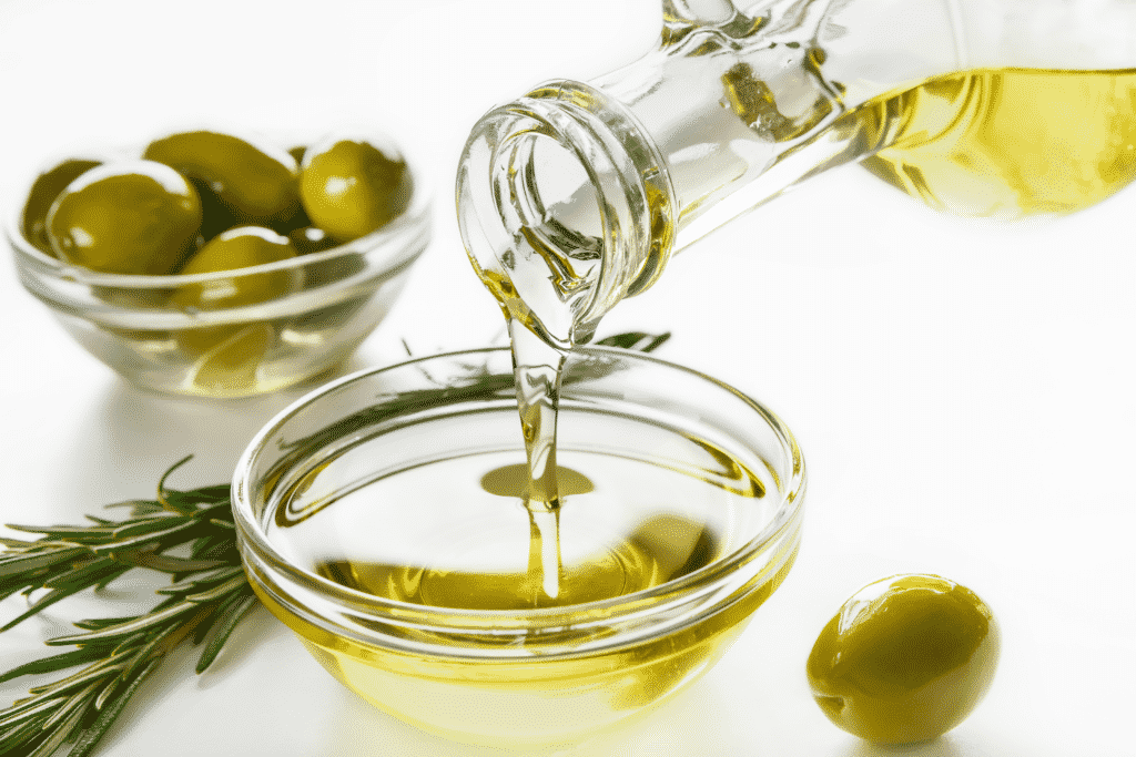 olie i skaal og groenne oliven